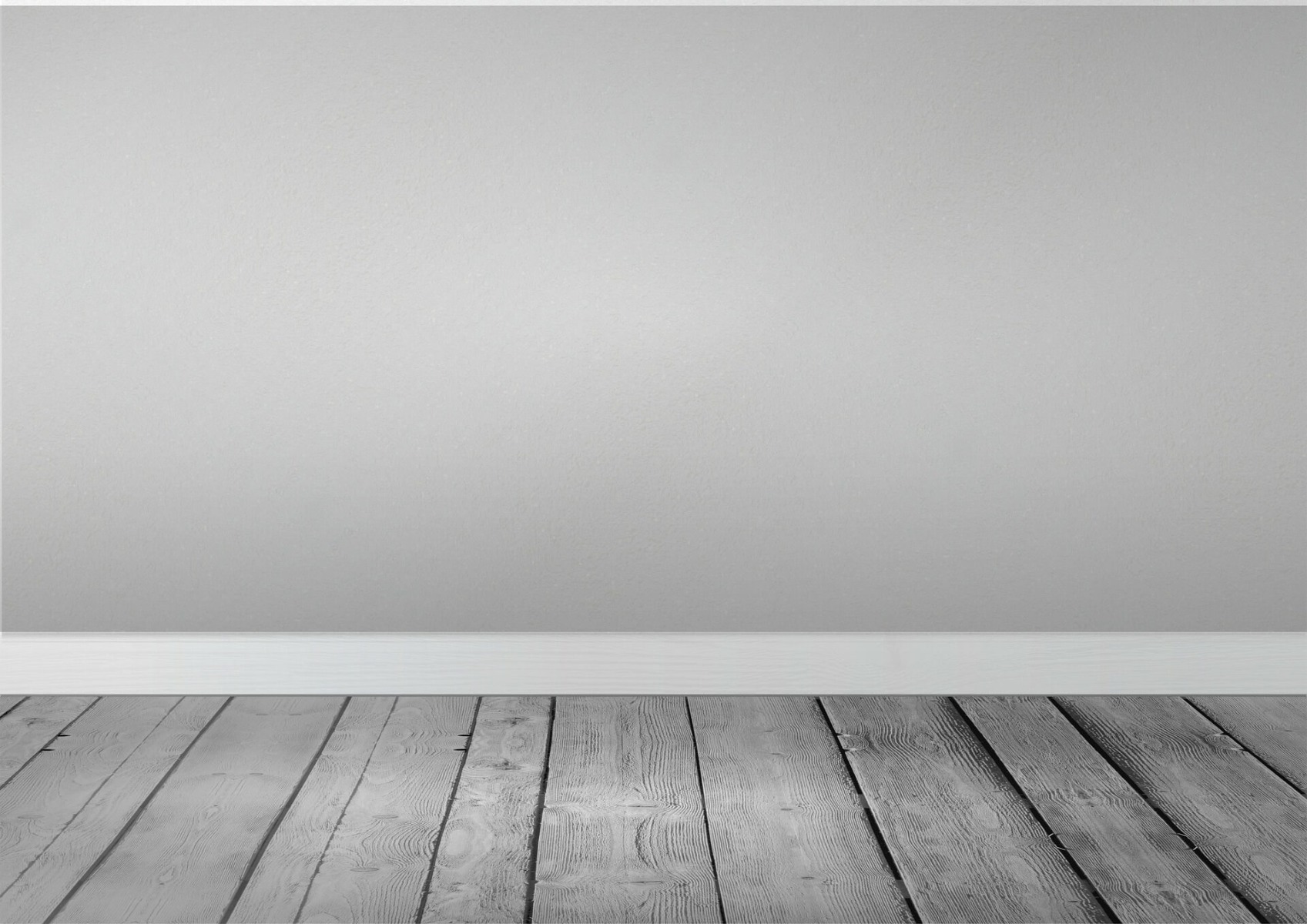 A photo of a grey painted wall and white skirting board with grey wooden flooring
